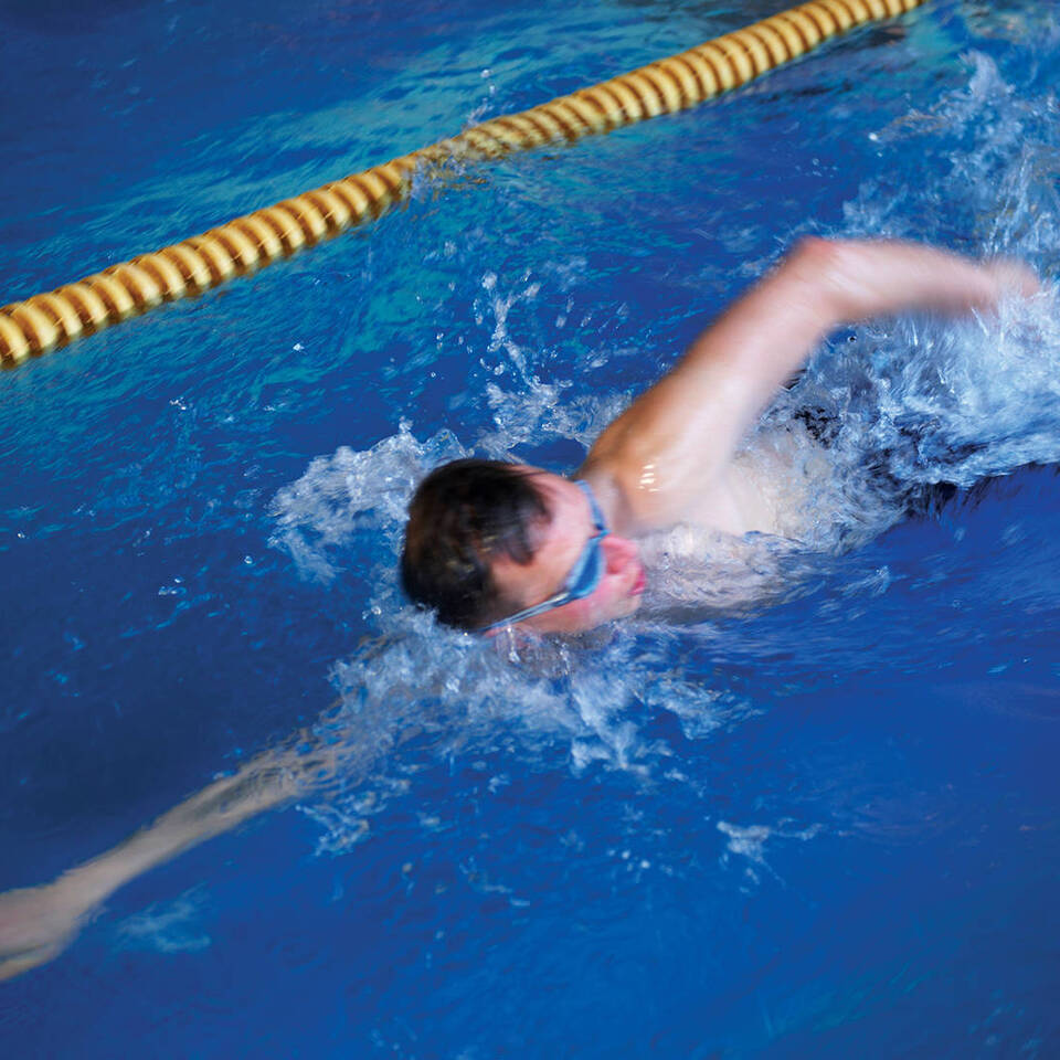 A male swimmer swimming lengths of Woodbury Park's swimming pool