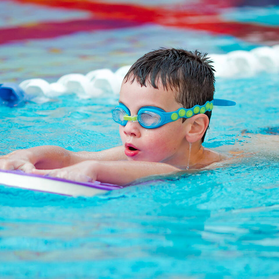 A child learning to swim during a swimming lesson in Woodbury Park's swimming pool